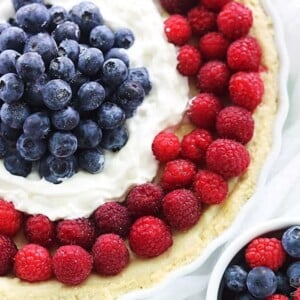 An image of a round tart decorated with blueberries and raspberries.