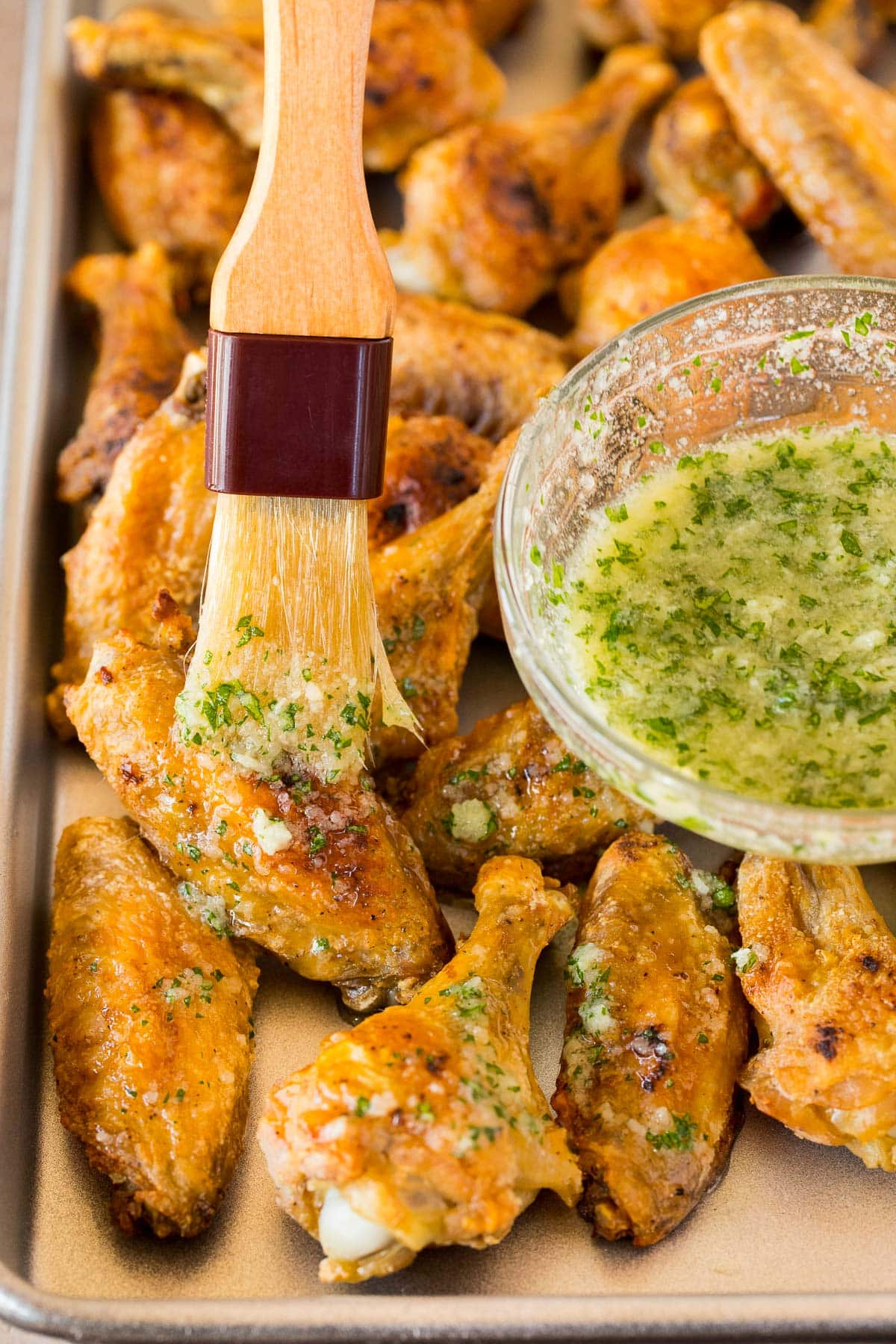 A brush coating chicken in garlic butter.