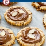 An image of almond roca cookies loaded with toffee and almonds and topped with creamy milk chocolate. on a marble slab.