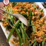 A bowl of bacon ranch green beans which are cooked in a ranch butter sauce and topped with crispy onions and bacon.
