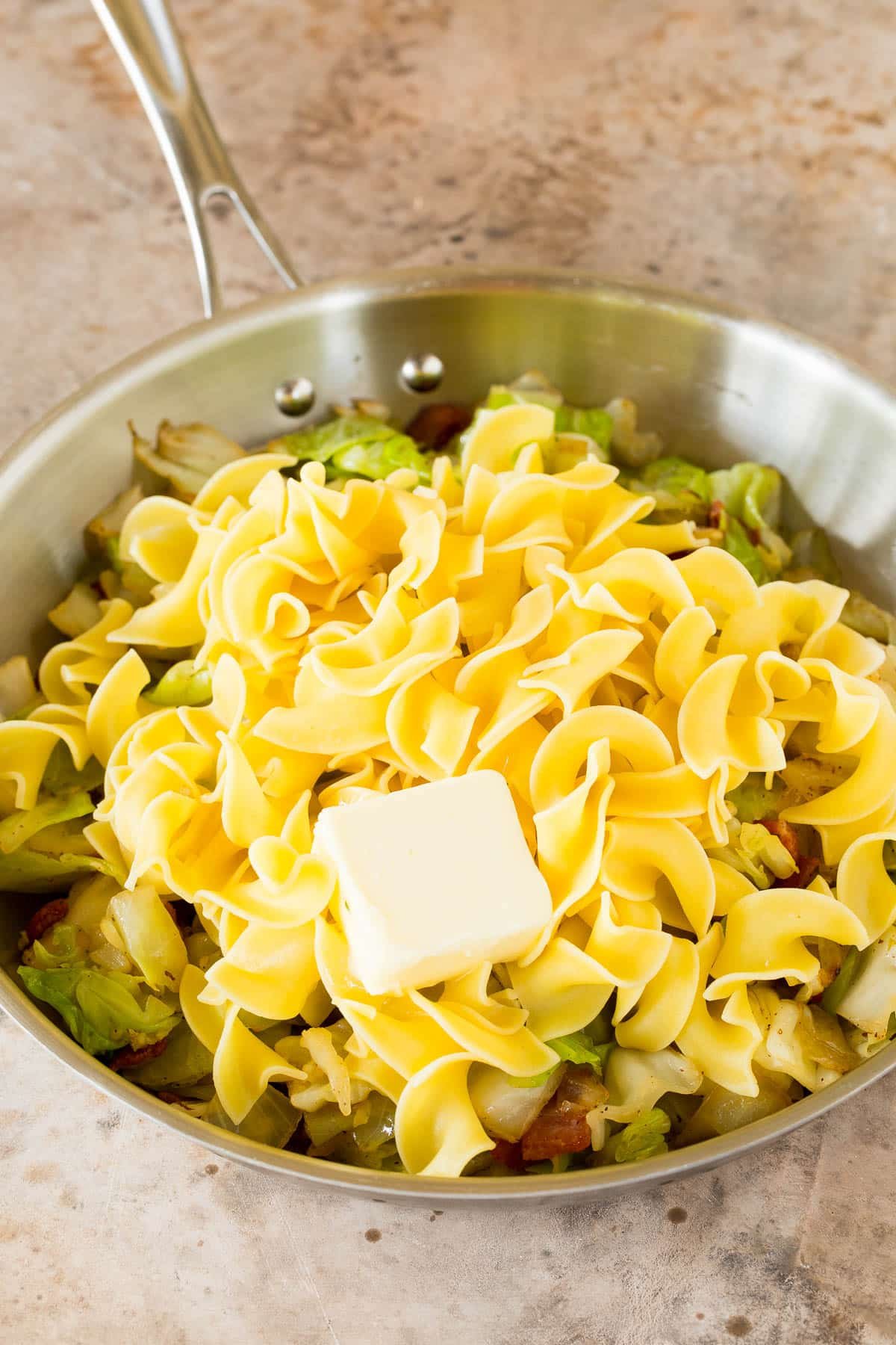 Cabbage and noodles in a skillet with butter.