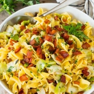 A bowl of haluski topped with bacon and parsley.