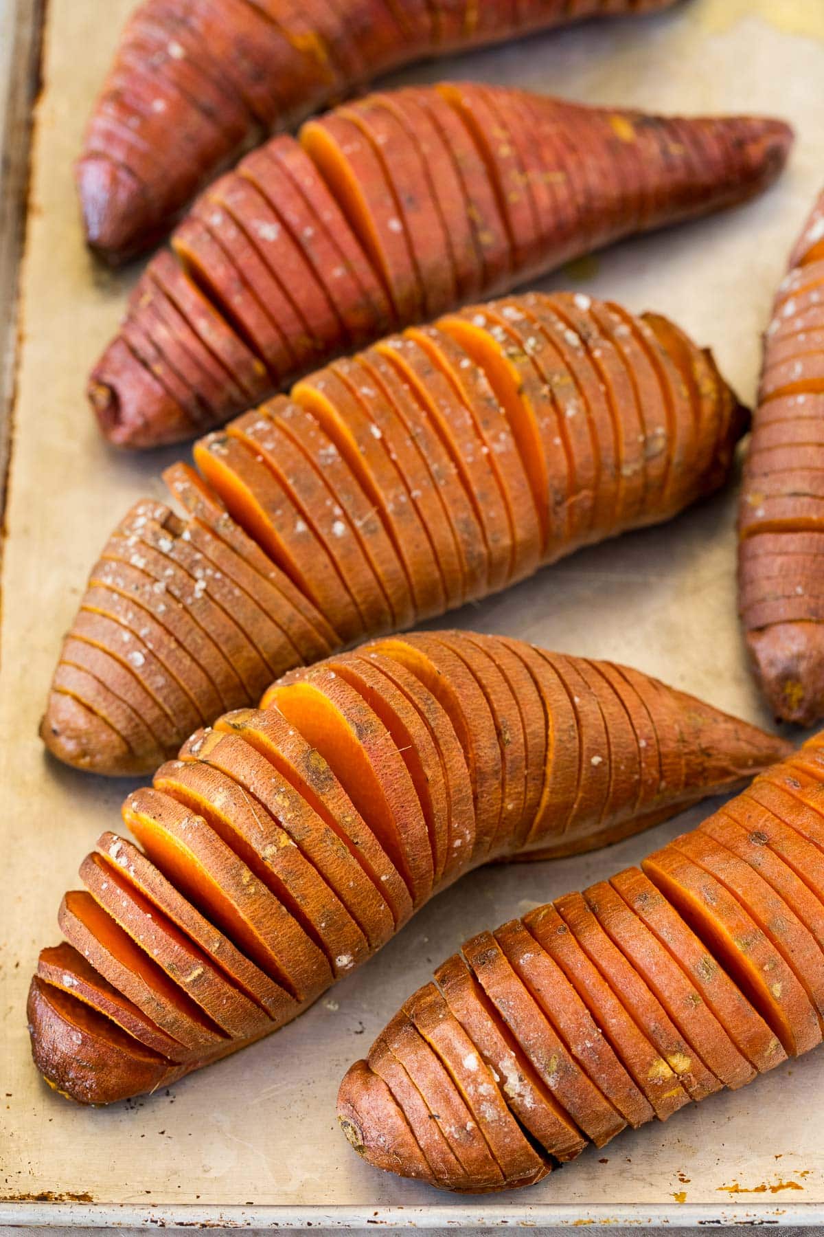 Sliced cooked sweet potatoes on a sheet pan.