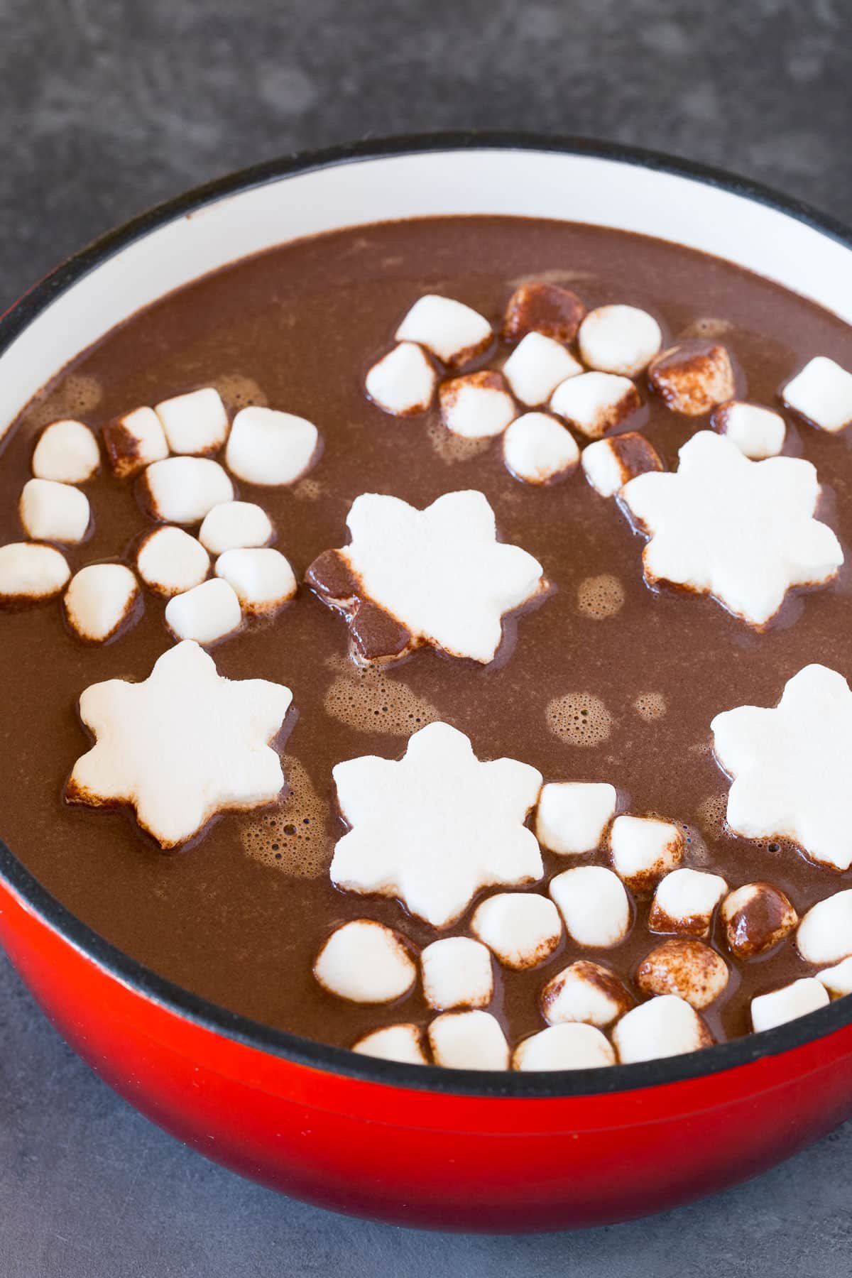A pot of hot chocolate with assorted marshmallows in it.