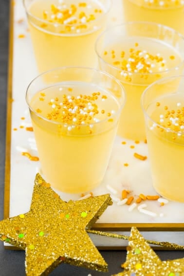 Champagne Jello shots on a marble tray with sprinkles on top.