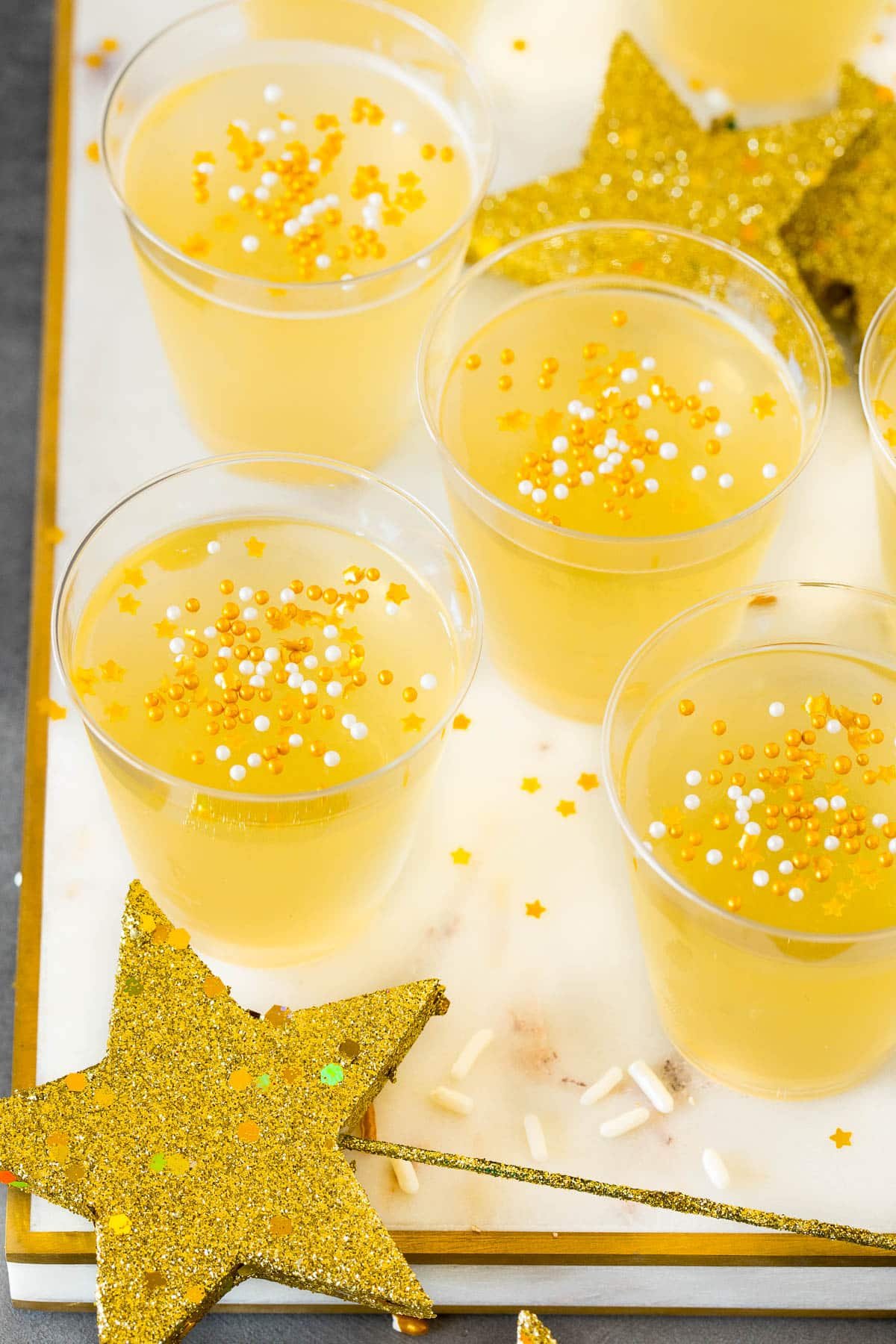 Champagne Jello shots topped with gold sprinkles.