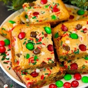 Christmas cookie bars on a plate with sprinkles and M&M candies as garnish.
