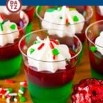 These Christmas Jello shots are layers of red and green gelatin mixed with vodka, then finished with whipped cream and holiday sprinkles.