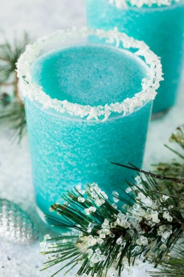 A glass of jack frost cocktail with a coconut crusted rim.