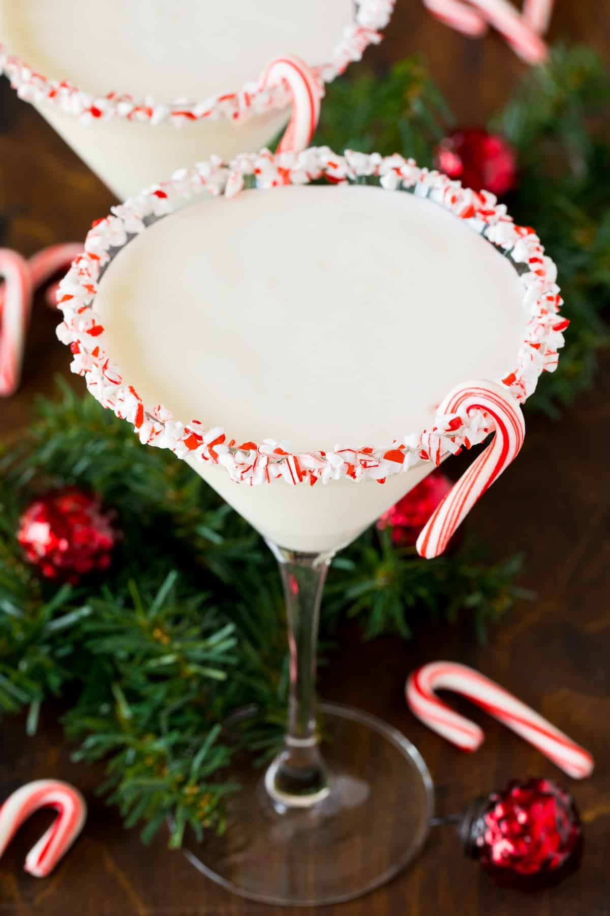 A peppermint martini in a candy cane coated glass.