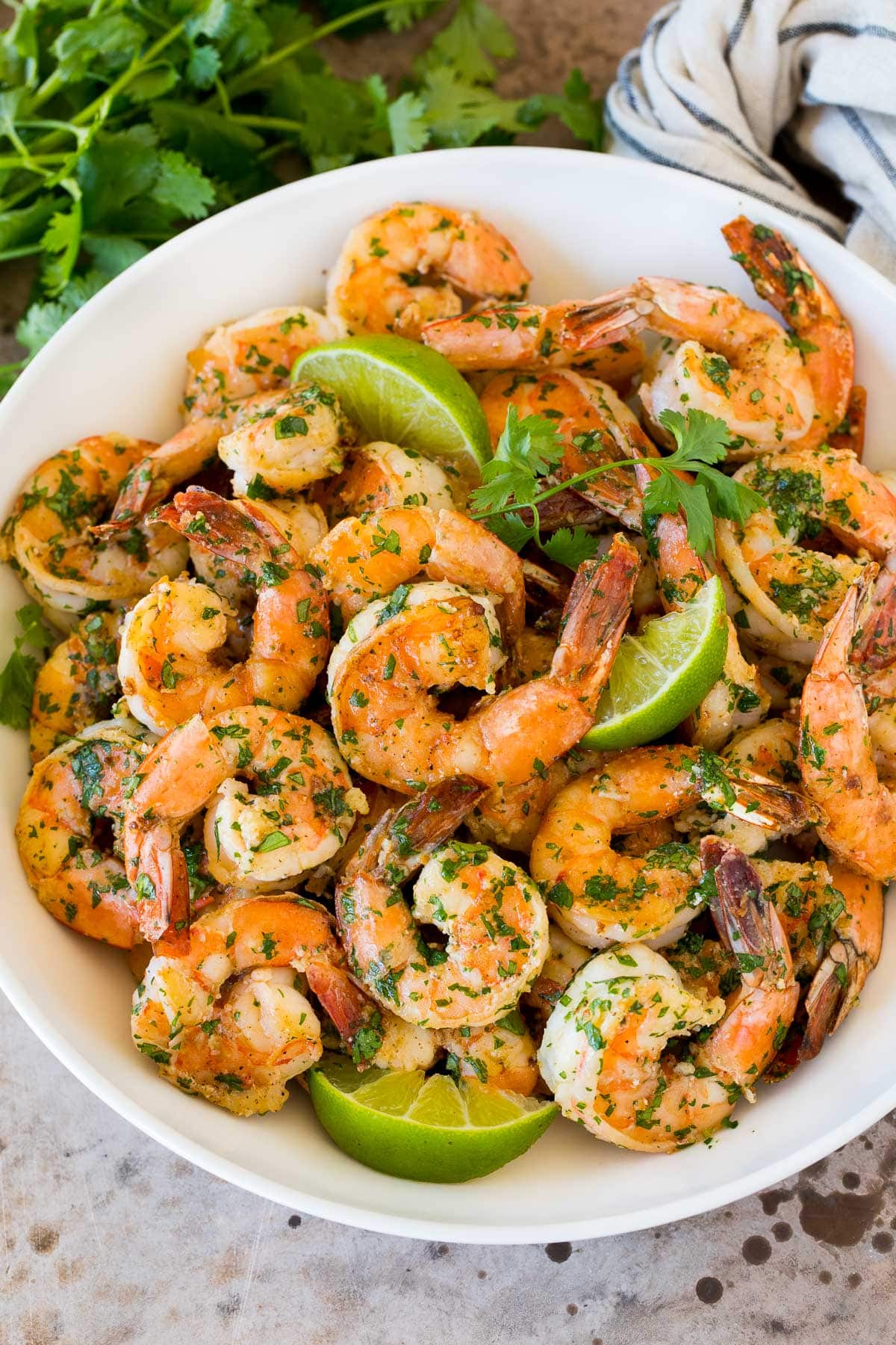 Cilantro Lime Shrimp | Seared Shrimp | Mango Salsa #salsa #shrimp #dinner #appetizer #sadud A serving bowl of cilantro lime shrimp with lime wedges in it.