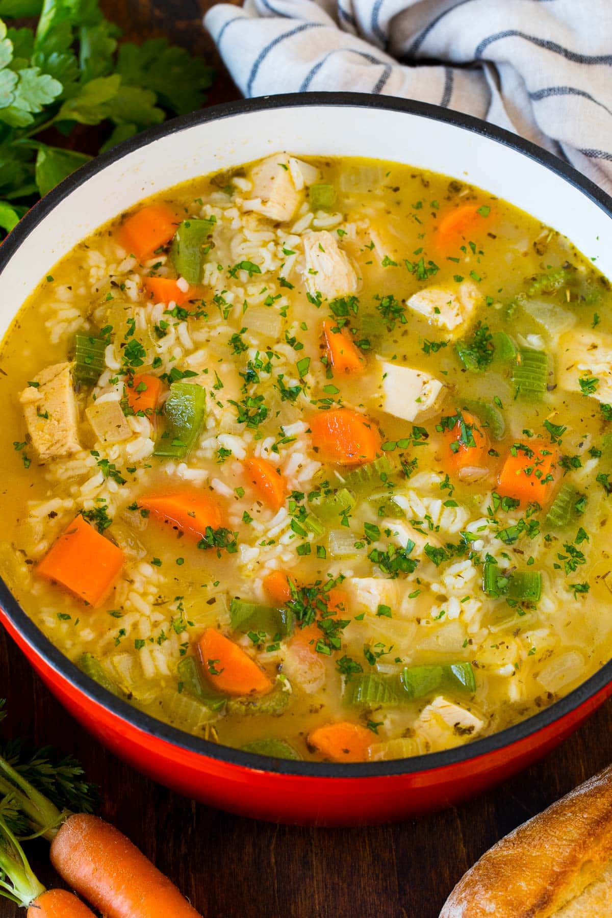 A pot of turkey and rice soup topped with fresh parsley.