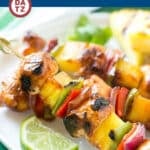A plate of Hawaiian chicken kabobs with marinated chicken, pineapple and veggies.
