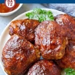 A plate with several smoked chicken thighs garnished with parsley.