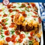 A scoop of pizza casserole being lifted out of a baking dish.