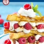 A plate of stuffed French Toast with raspberries and chopped almonds.