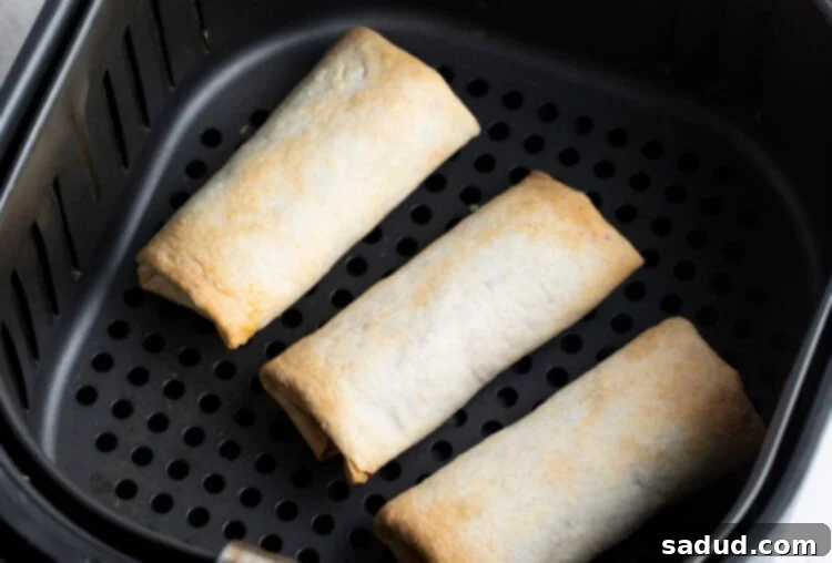 Cooked burritos in air fryer, showing even browning