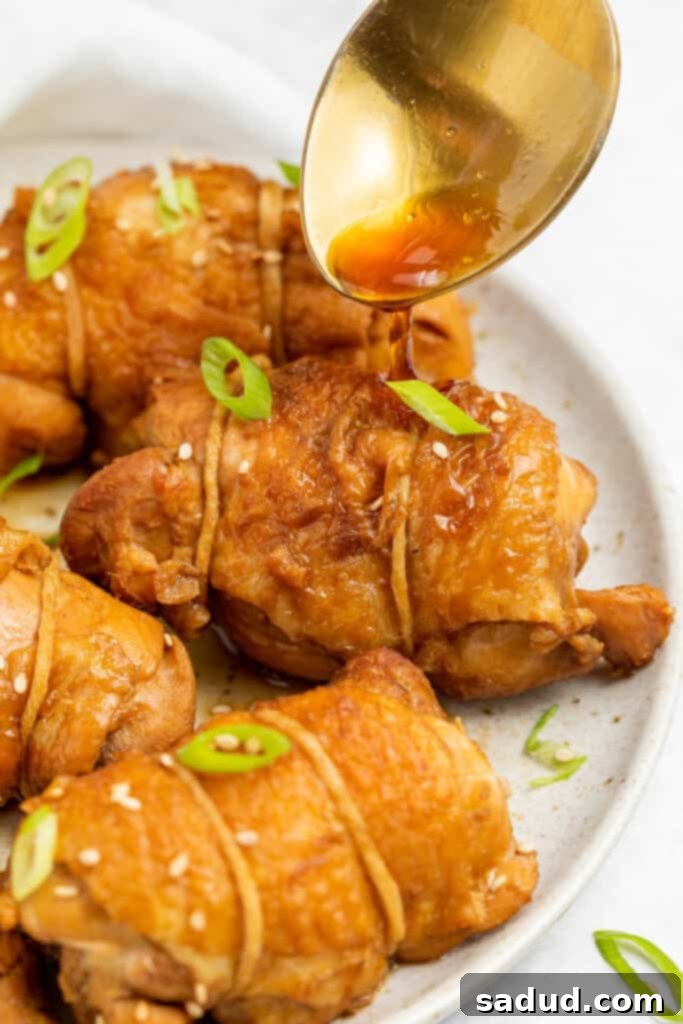 sauce being spooned over chicken chashu on a plate
