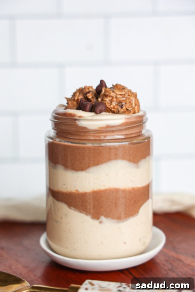 Decadent Chocolate Peanut Butter Mousse Chia Pudding in a glass jar, topped with coconut whipped cream and chocolate shavings.