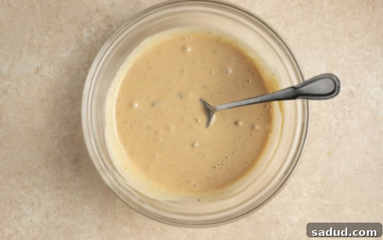 Burger sauce in glass bowl with spoon, showing its creamy texture