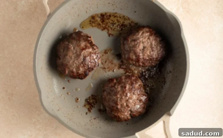 Cooked buffalo burger patties in large skillet, showing a beautiful sear