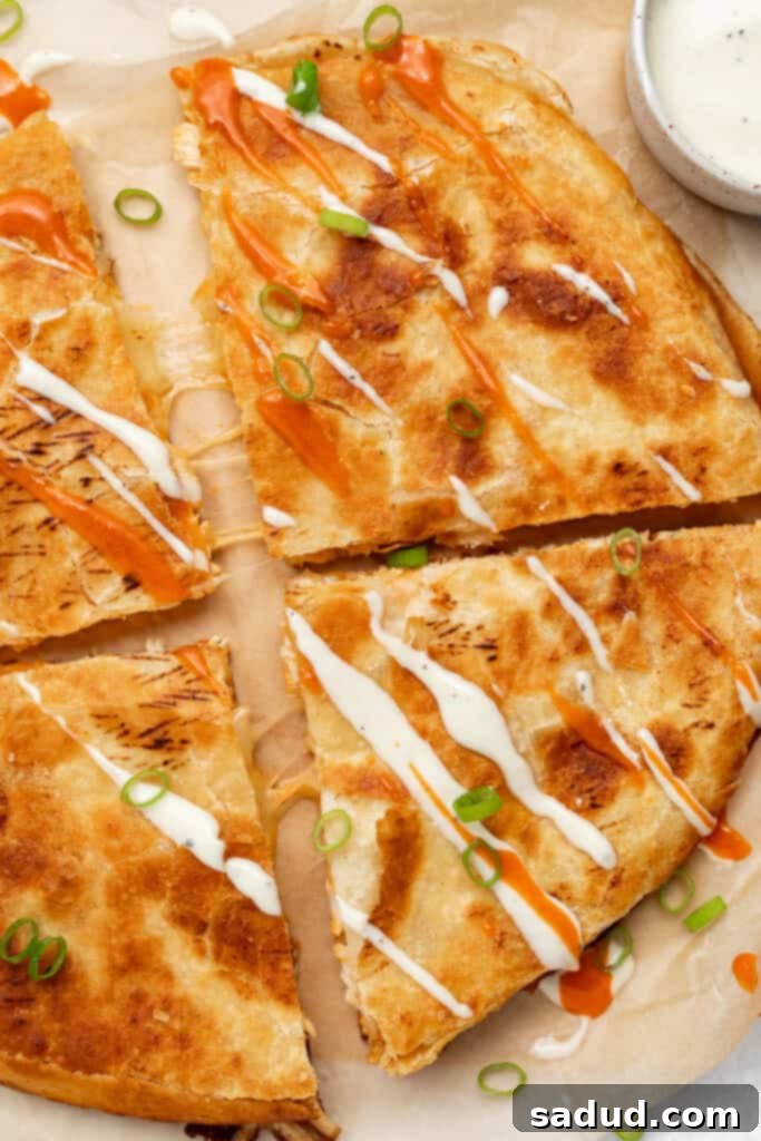 overhead image of buffalo chicken quesadillas with ranch dressing and buffalo sauce drizzled on top