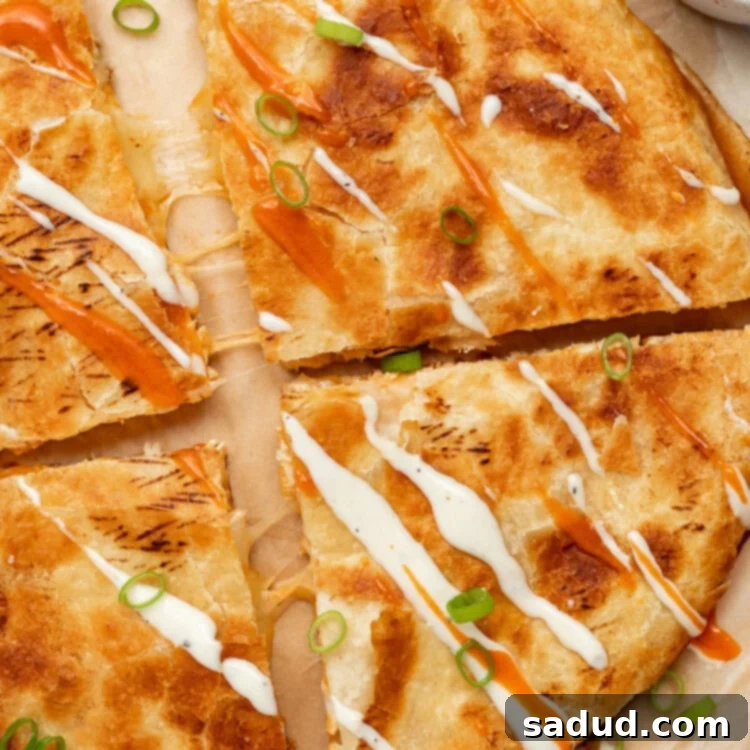 overhead image of buffalo chicken quesadillas with ranch dressing and buffalo sauce drizzled on top
