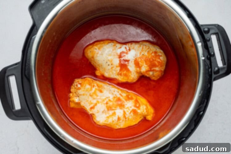 Instant Pot set to cook with chicken and sauce inside