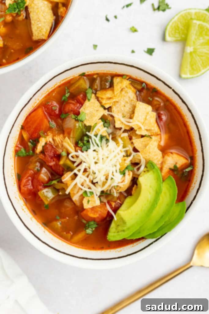 chili's southwest chicken soup in a bowl with crushed tortilla chips, cheese, and sliced avocado on top