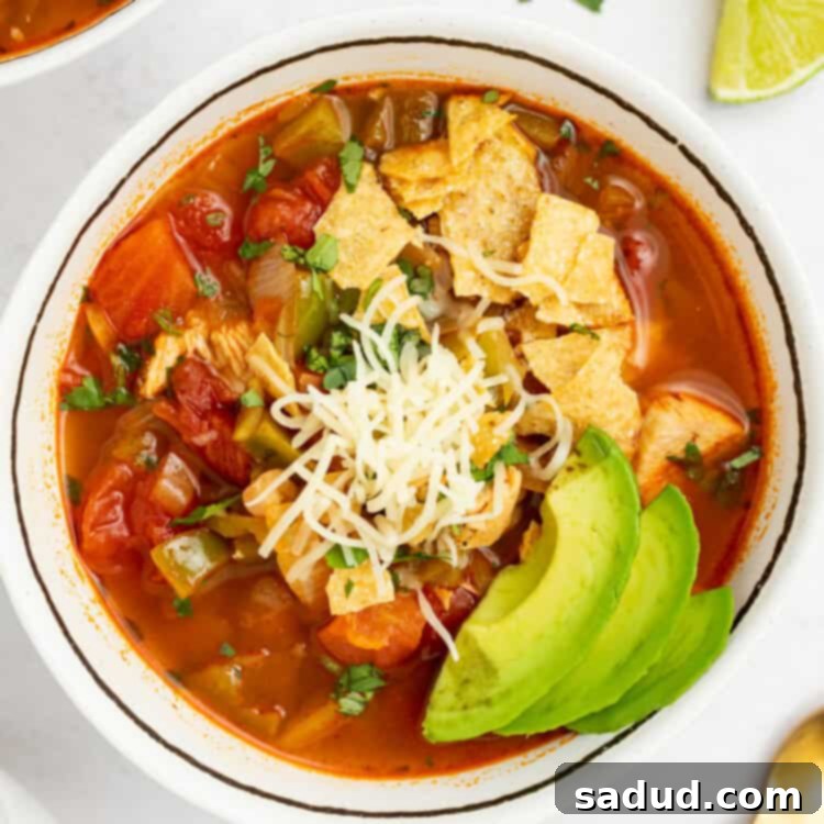 chili's southwest chicken soup in a bowl with crushed tortilla chips, cheese, and sliced avocado on top