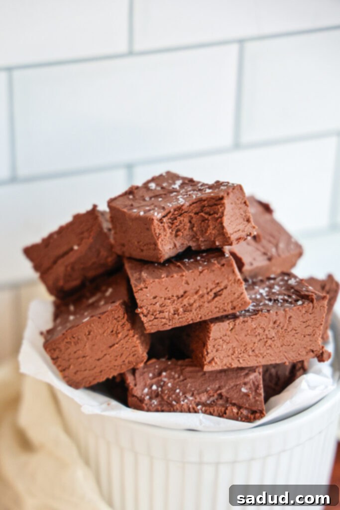 A bowl filled with small, perfectly cut squares of healthy chocolate fudge, sprinkled with sea salt.