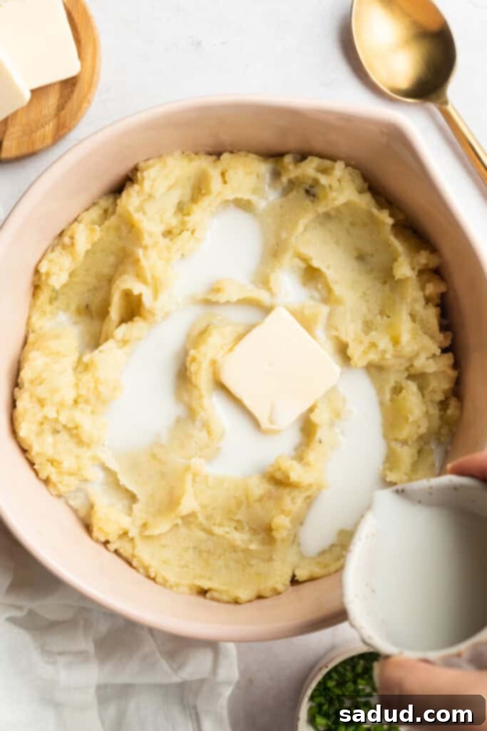 The Best Three Ways to Reheat Mashed Potatoes 2 pouring milk into a bowl of mashed potatoes and butter