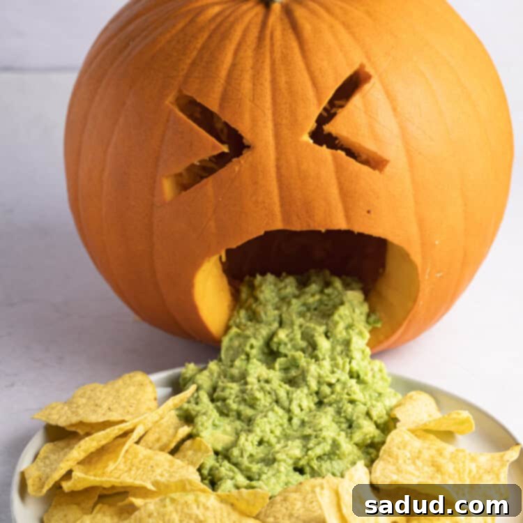 Close-up of a puking pumpkin with guacamole and tortilla chips, ready for a Halloween party