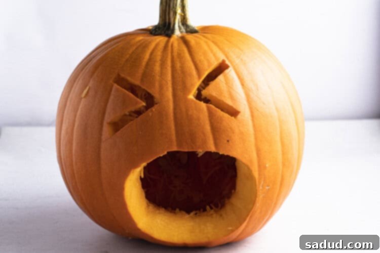 A pumpkin with a face carved into its front, ready to become a puking pumpkin