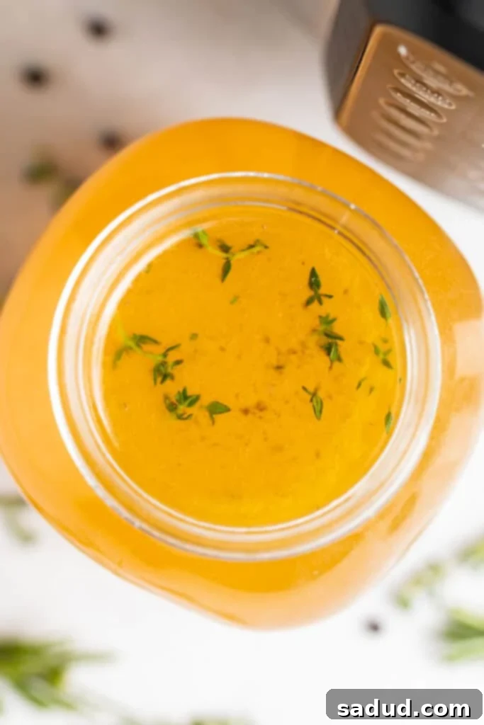 overhead image of instant pot turkey stock with fresh herbs on the side
