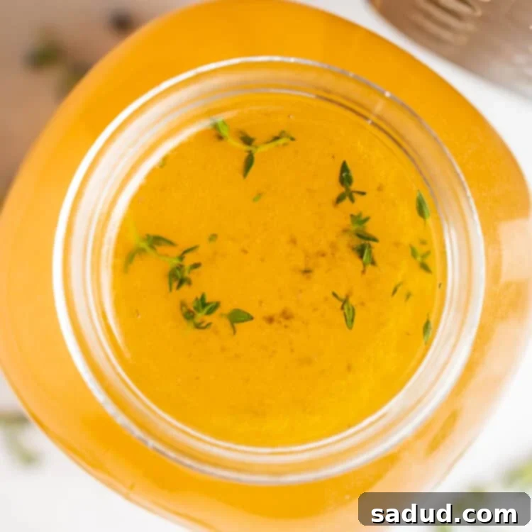 overhead image of instant pot turkey stock with fresh herbs on the side