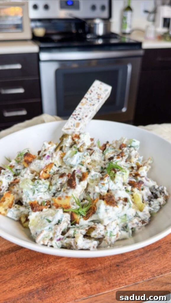 Crispy Smashed Potato Salad, garnished with fresh herbs, ready to be served.