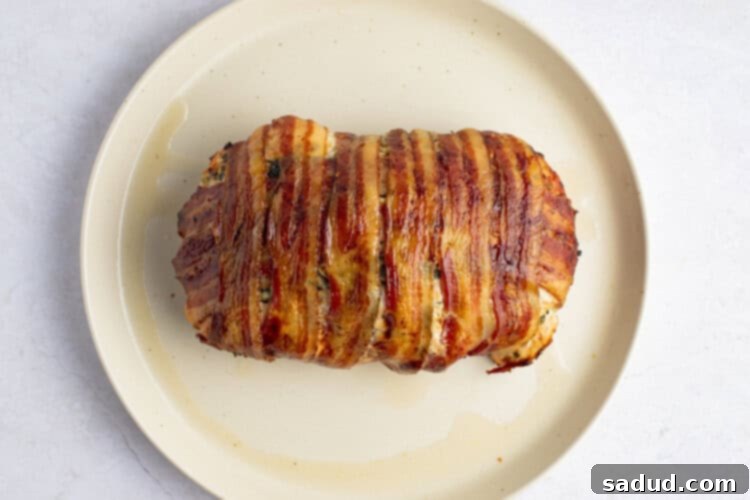 Cooked bacon wrapped turkey breast on plate