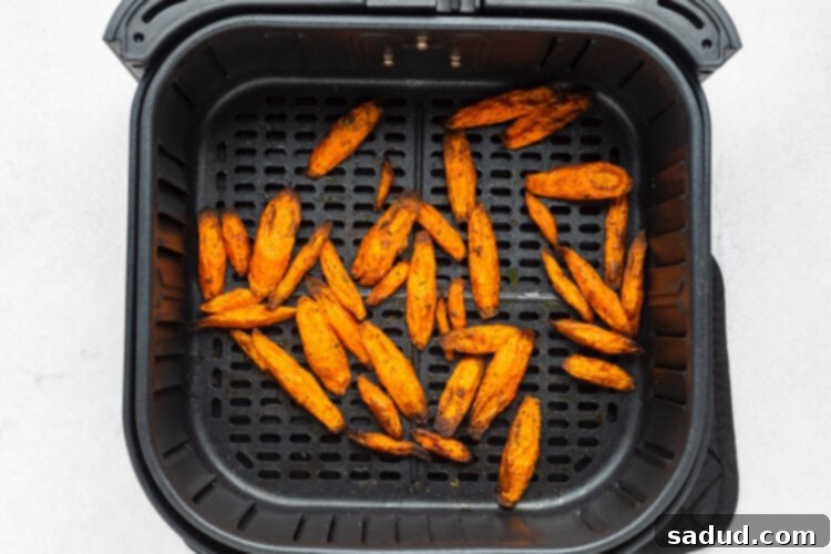 Air fryer carrots in an air fryer basket after cooking.