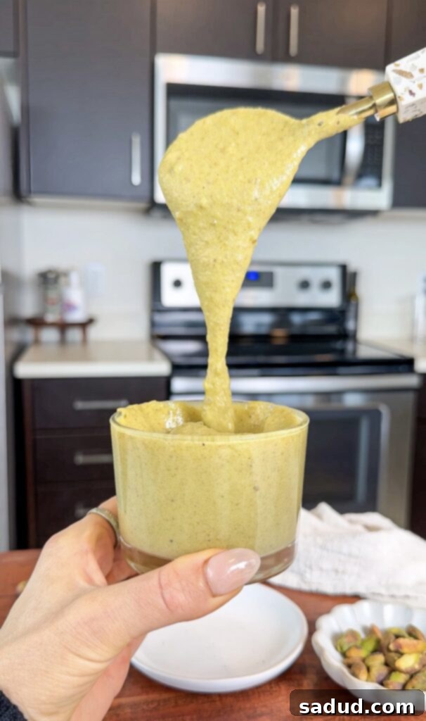 Homemade pistachio cream spread in a glass jar, showing its creamy texture