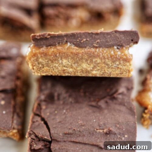 Close-up of a Caramel Cookie Dough Bar, showing the texture of the cookie dough, the gooey caramel, and the chocolate top
