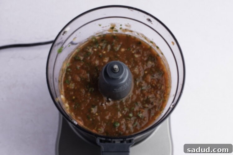 Keto salsa being processed in a food processor for perfect chunky texture