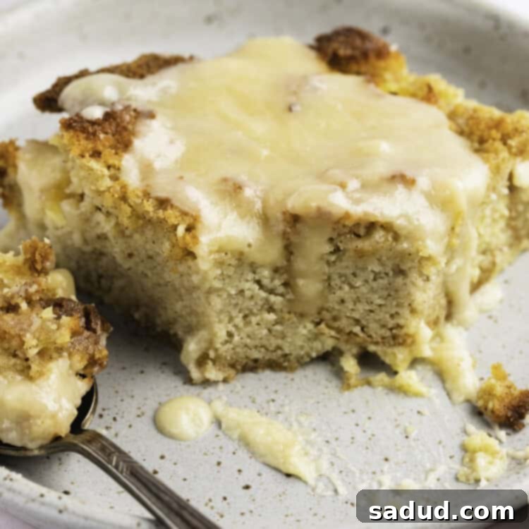 Close up of a square of keto bread pudding on a plate, showcasing its golden crust and creamy interior.