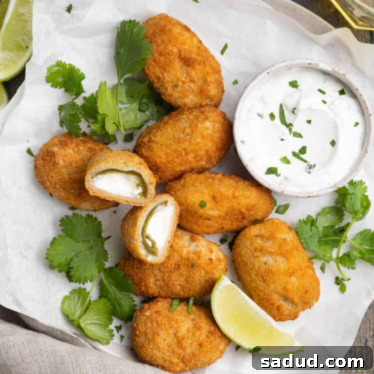overhead image of air fryer frozen jalapeno poppers on a plate with cilantro lime dipping sauce on the side
