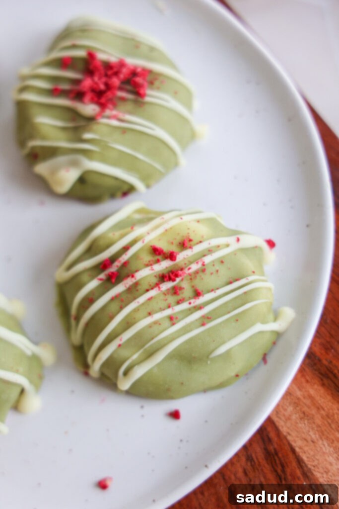 Close-up of frozen yogurt bites on parchment paper before chocolate coating.