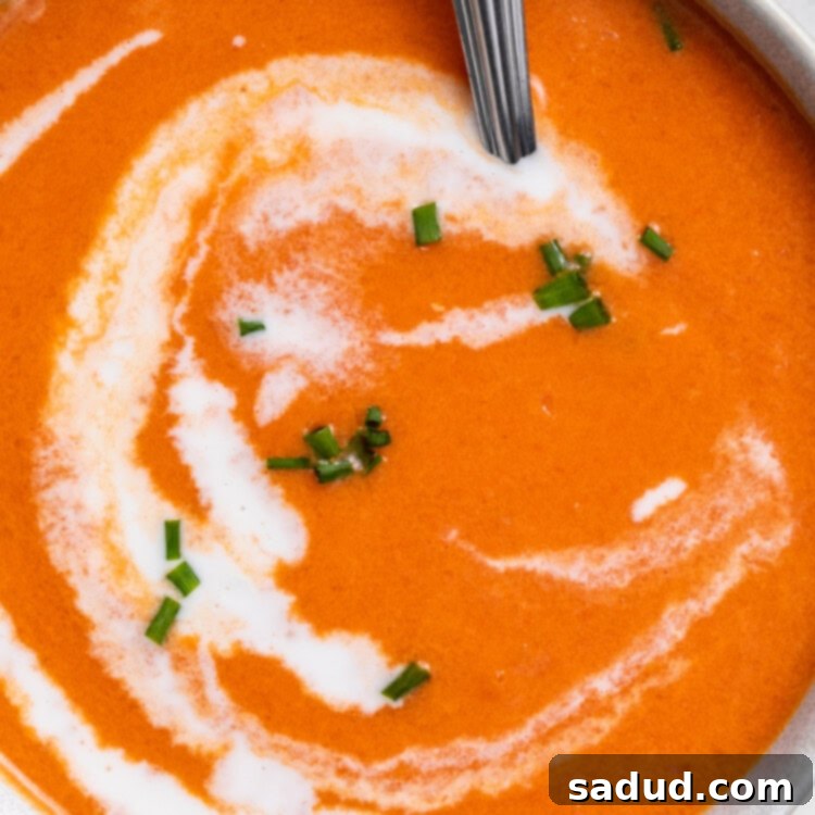 close-up overhead image of gluten-free tomato soup in a bowl with heavy cream swirled on top