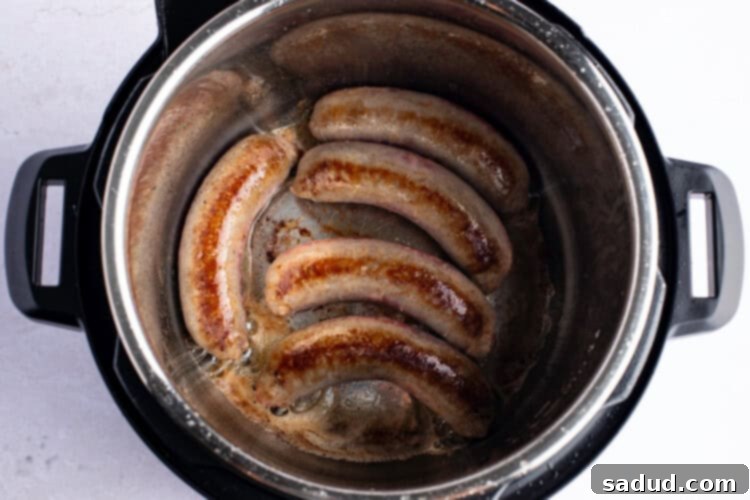 Overhead photo of bratwurst in Instant Pot with melted butter.