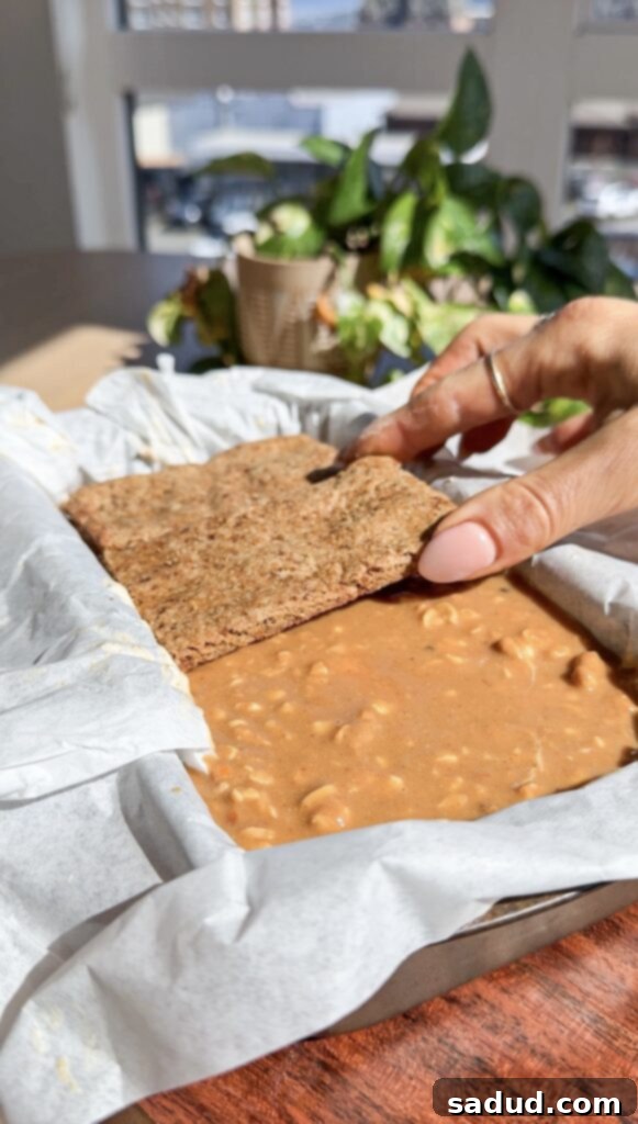 Pouring nut butter caramel over the whipped topping.