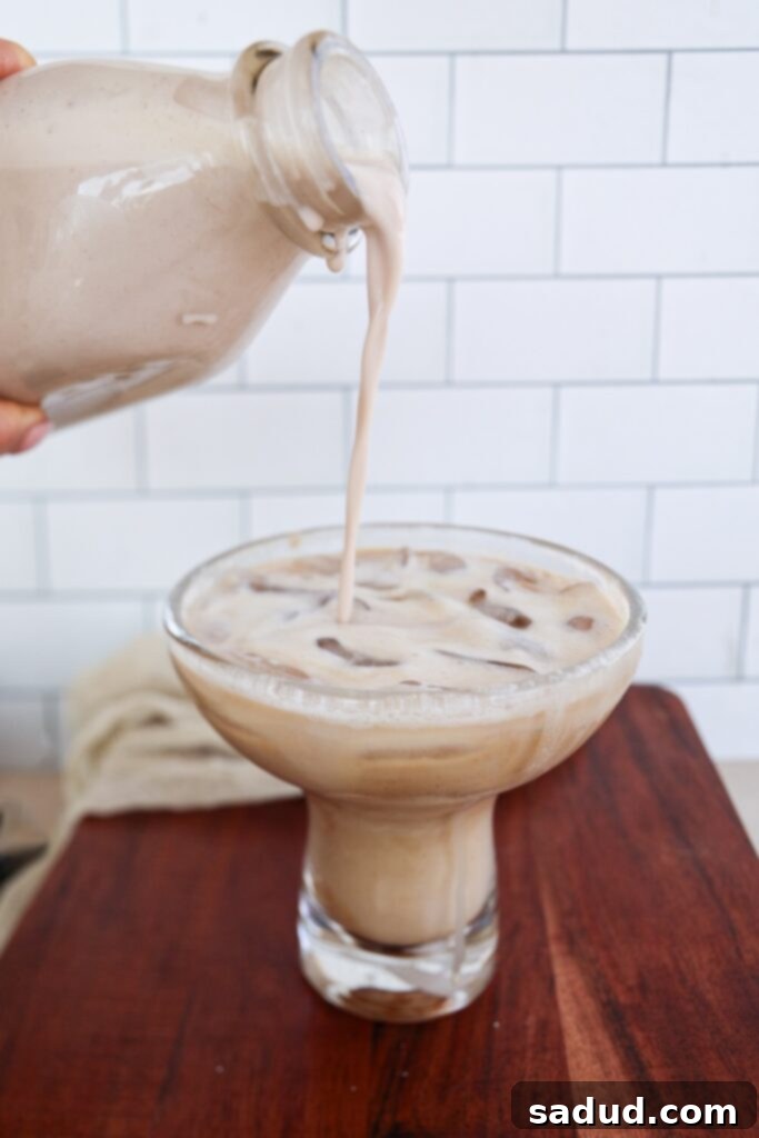 Rich and creamy Dairy-Free Salted Caramel Coffee Creamer in a glass bottle next to a coffee cup.