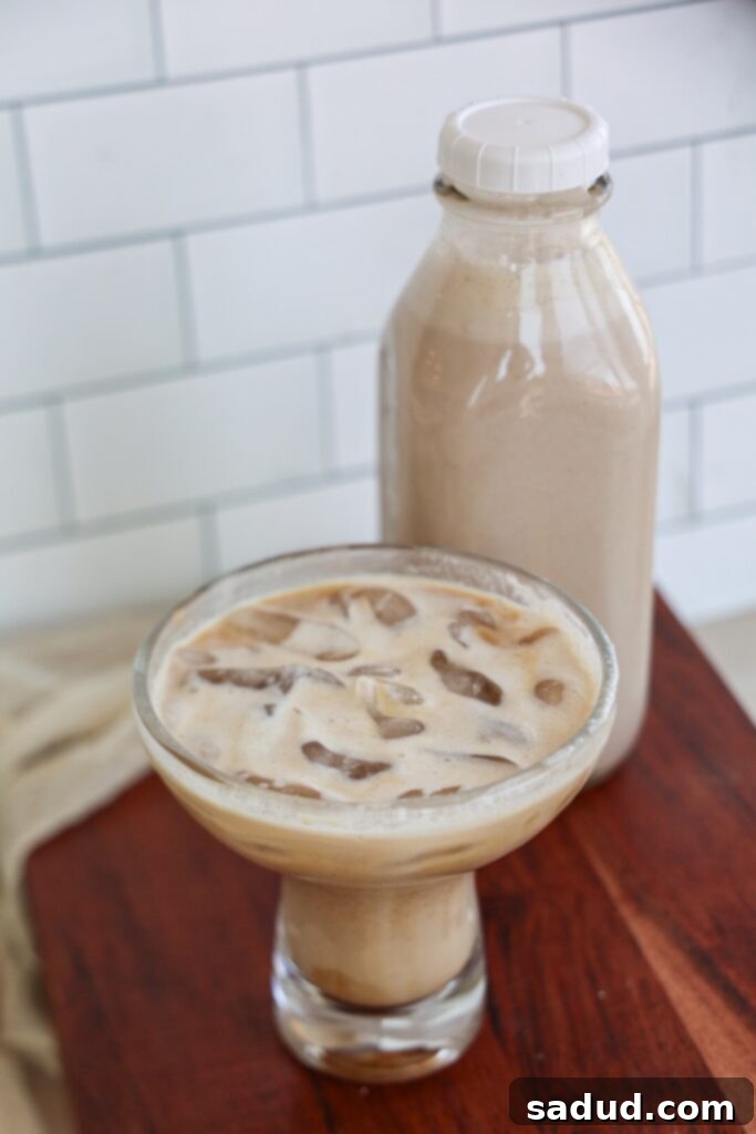 Creamy vegan coffee creamer poured into a glass with coffee.